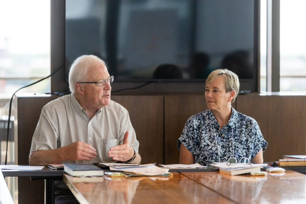 Paul J. Wadell speaking with a colleague at a seminar table